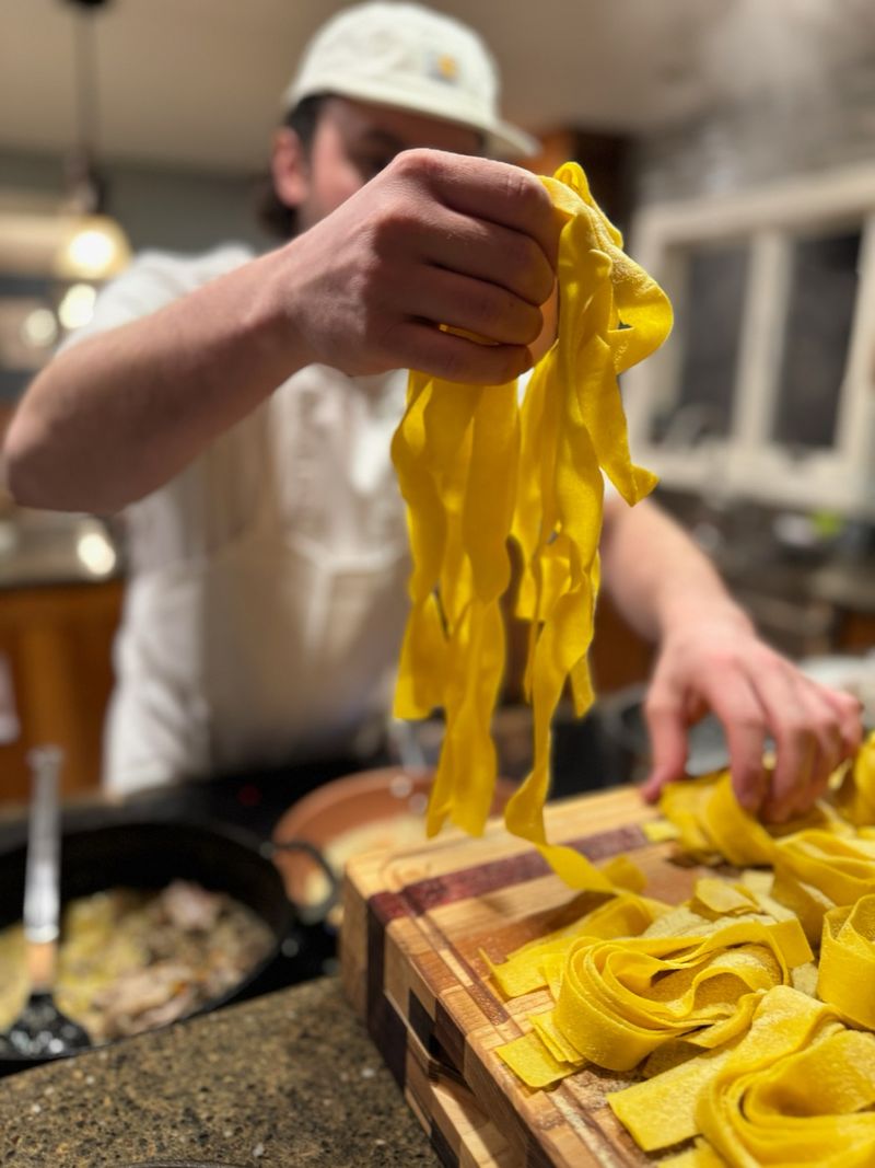 Anthony working fresh pappardelle by hand over a cutting board