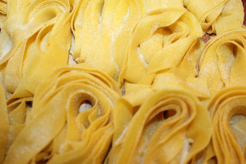Fresh pappardelle nests dusted with semolina