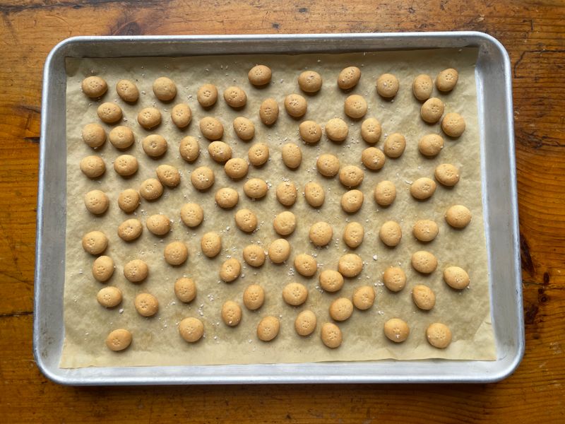 A sheet tray of small round baked oyster crackers
